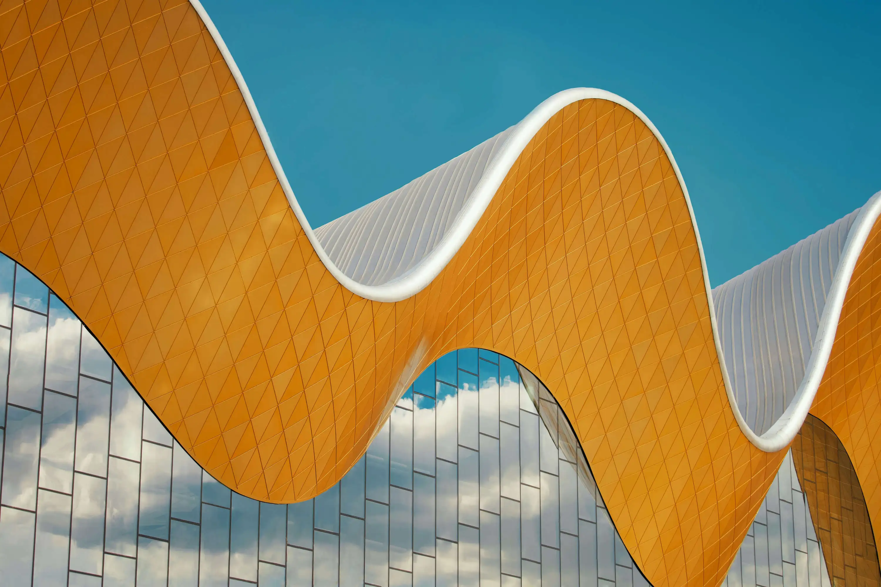 Wellenförmige orange Skulptur symbolisiert Flexibilität und Innovation im Executive Search bei Heinrich & Coll.